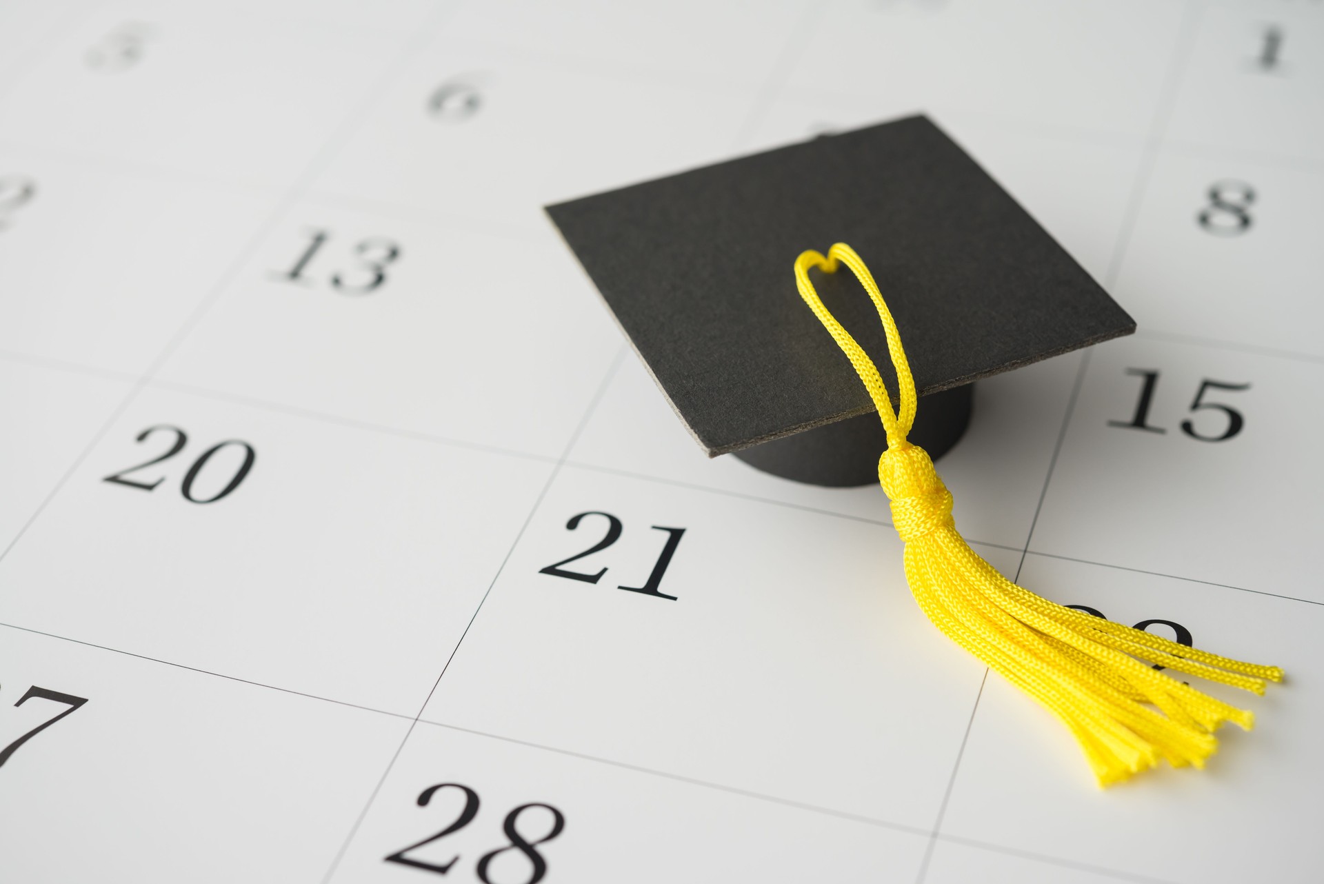 Graduation cap or mortarboard on white blank calendar background.